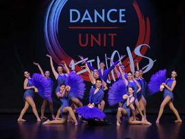 Tanzgruppe mit lila Outfits auf Bühne