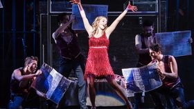 Sängerin auf Bühne mit mehreren männlichen Tänzern um sie herum