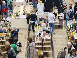 Ausstellungsregale mit Produkten und stöbernde Besucher