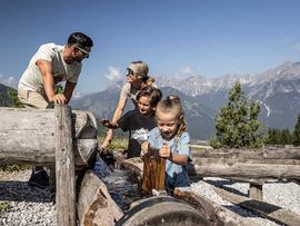 Familie bei Wasserstelle der Serleslifte Mieders