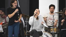 Mehrere Sänger und Musiker auf Bühne mit Instrumenten