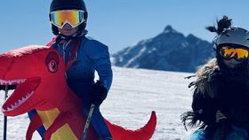Zwei verkleidete Kinder im Skioutfit und Dinotier