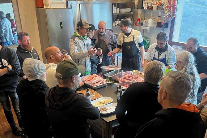 einige personen schauen bei der verarbeitung von dem Grillfleisch zu