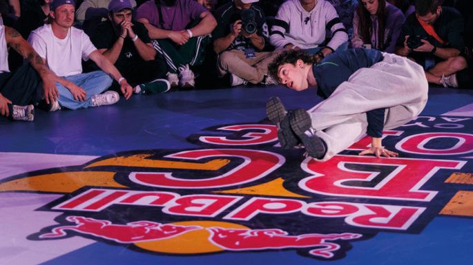 Mann macht Breakdance-Moves auf einem Hallenboden