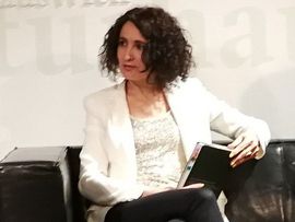 ©Poprad Porträt der Autorin Regina Hilber sitzend auf einem Ledersofa mit Notizbuch in der Hand bei einer Literaturveranstaltung.