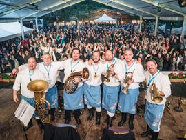 Band-Portrait mit Blasinstrumenten vor vollem Zuschauerraum