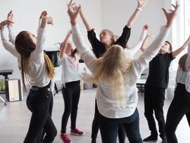 Frauen heben in Tanzbewegungen die Arme in die Luft