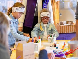 Kinder bei einem Basteltisch